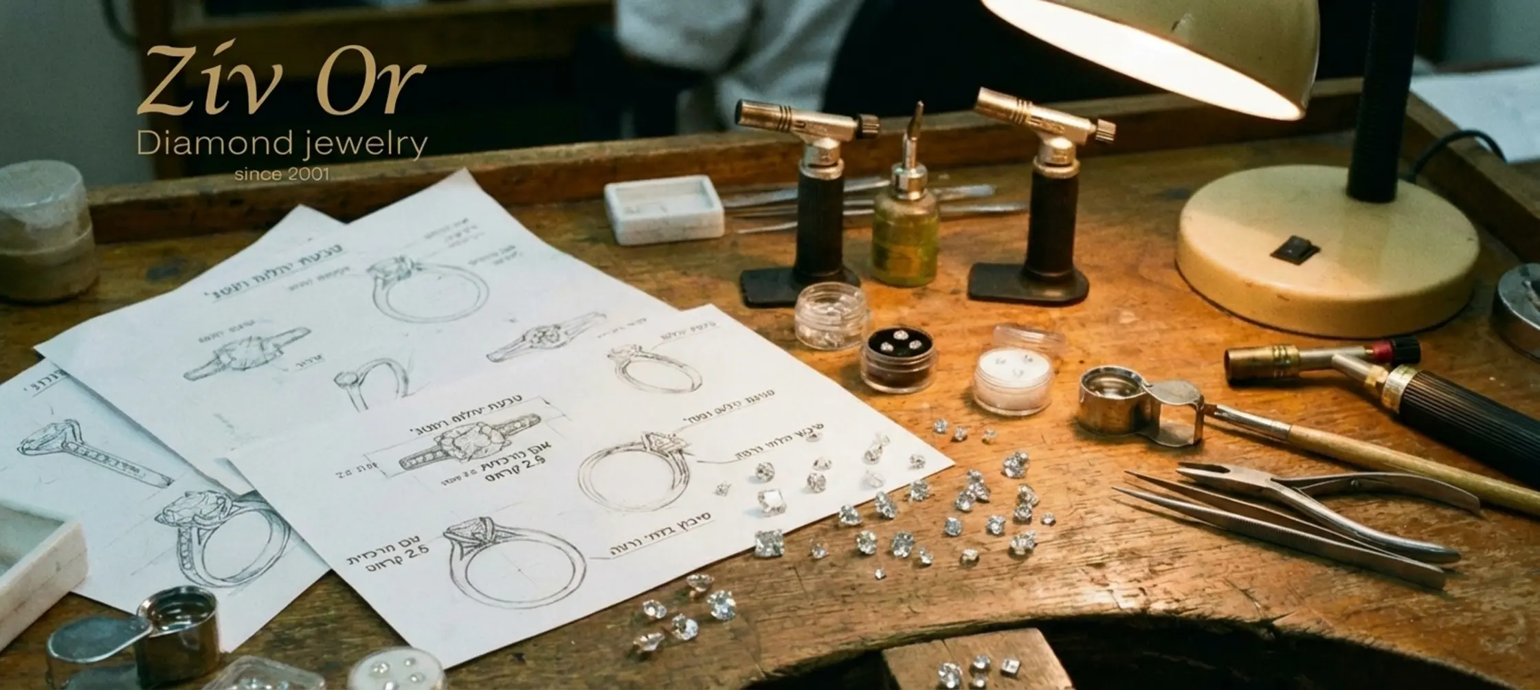 צילום תקריב של שולחן עבודה מעץ מלא במפעל בבורסה ליהלומים, עליו מונחות סקיצות מפורטות של עיצוב תכשיטים, כלי עבודה עדינים של צורפים, ויהלומים מנצנצים במידות שונות הממתינים לשיבוץ מקצועי