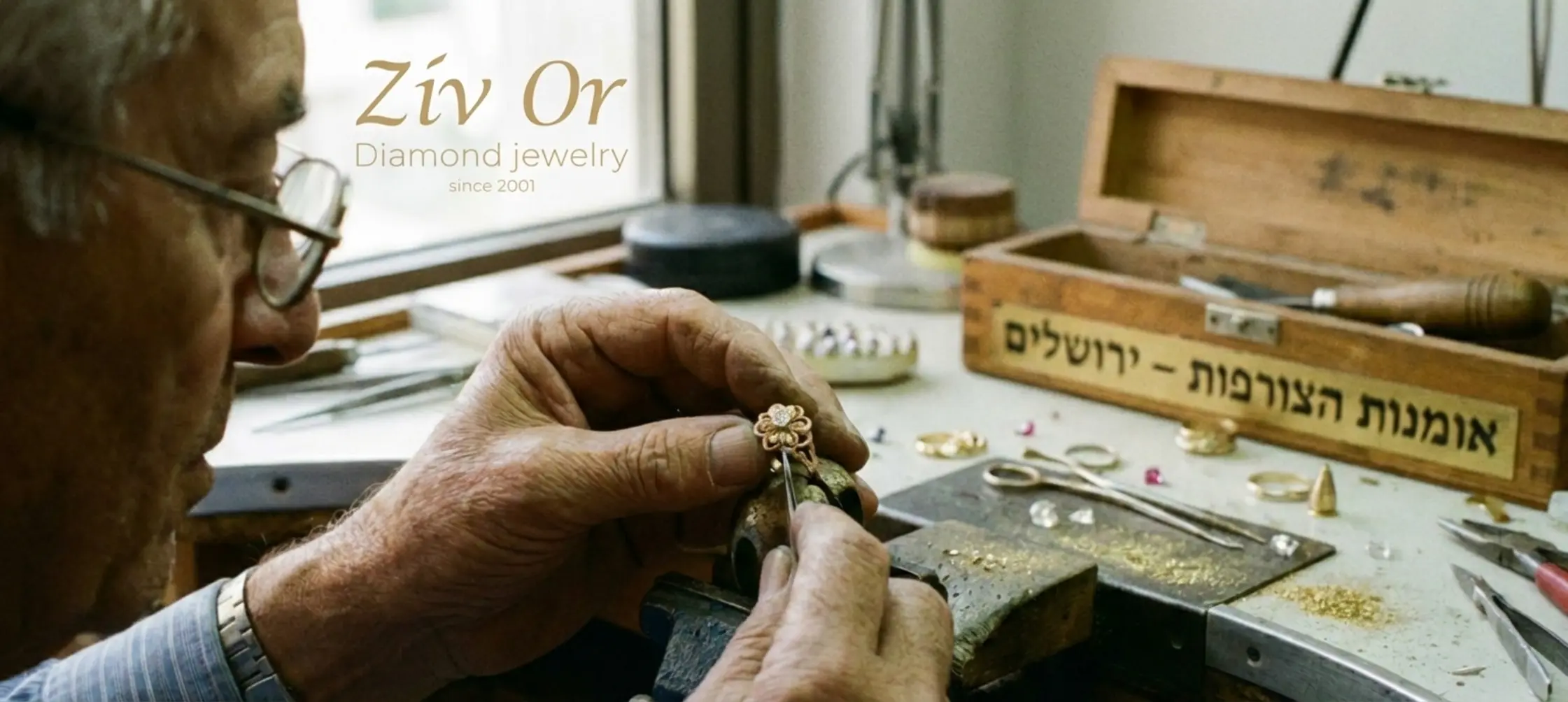 תמונה המציגה תקריב של ידי צורף משבץ יהלום בתוך תכשיט עדין, הממחישה את עבודת היד והדיוק