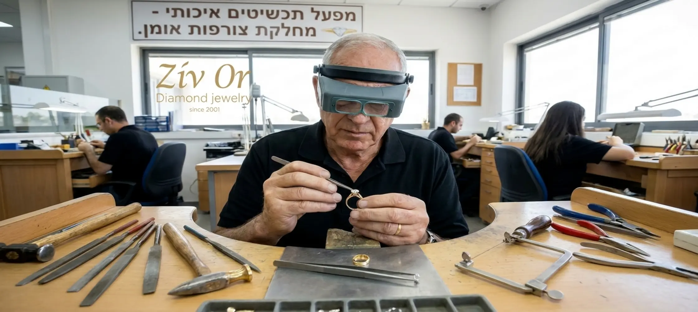 תמונה של צורף מומחה מרכיב יהלום בתוך טבעת זהב במפעל תכשיטים מואר ומקצועי, עם כלי עבודה עדינים מפוזרים על השולחן